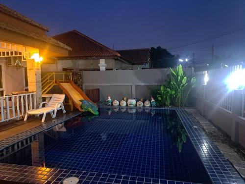 a small swimming pool in a backyard at night at Bluepool Villa Pattaya in Bang Sare