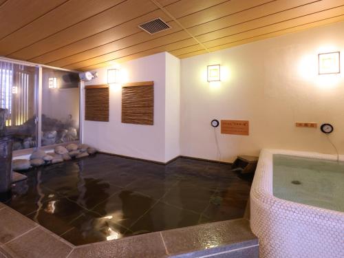 a room with a bath tub in the middle of a room at Dormy Inn Tsu in Tsu