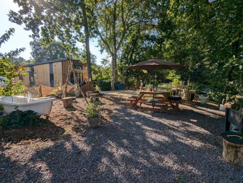 a backyard with a tub and a table and an umbrella at Hausboot Friedrich in Papenburg