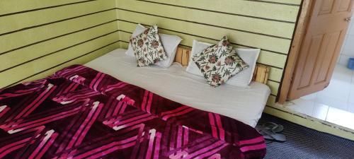 a bed with pillows on it in a room at New snow view resort pahalgam in Pahalgām