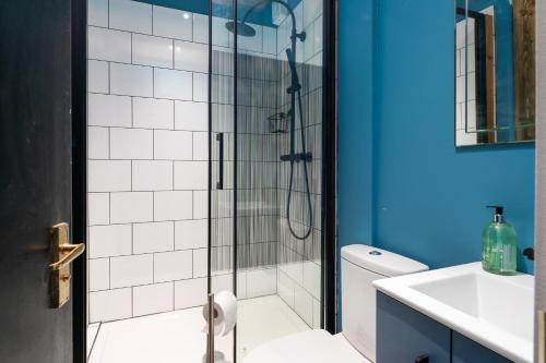 a bathroom with a shower with a glass door at 1BR Stylish Flat by HostaraHomes, Near Liverpool Street, Prime London Location, Sleeps up to 4 in London
