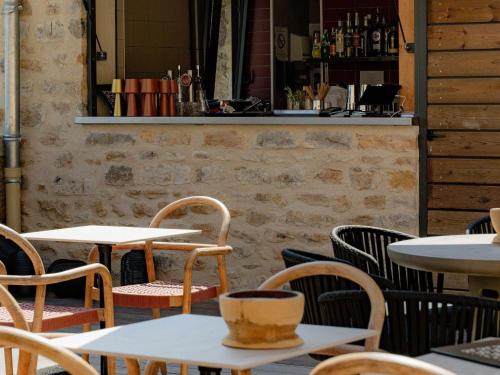 a restaurant with tables and chairs and a bar at Hôtel Fort St Laurent Lyon - Handwritten Collection in Lyon