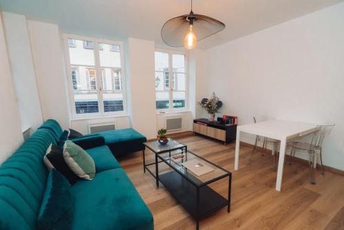 un salon avec un canapé bleu et une table dans l'établissement Magnifique appartement 2 pièces en hyper centre, à Strasbourg
