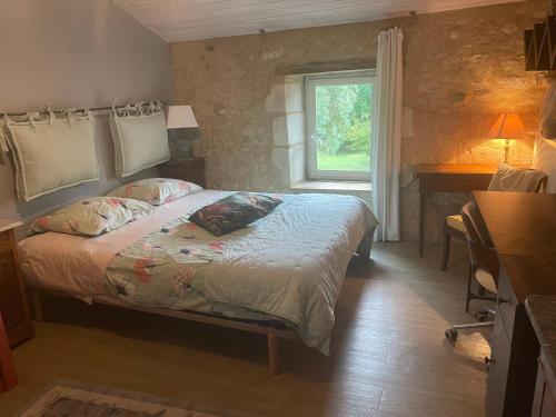 un dormitorio con una cama y una ventana en La Poitevinière, en Sainte-Hermine