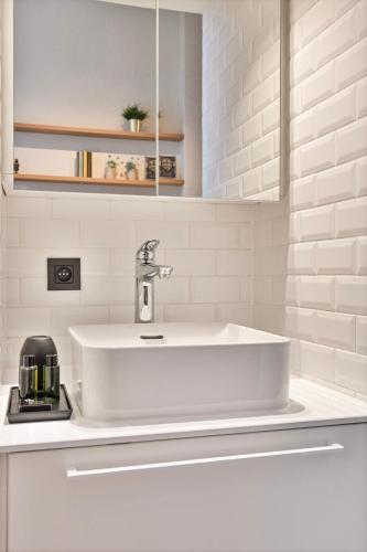 a white sink in a white bathroom with a counter at Borgerhouse B&B in Antwerp