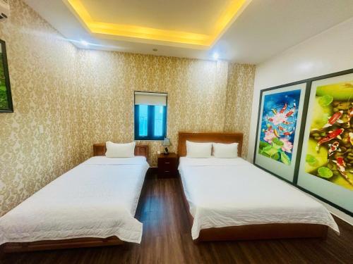a room with two beds and a painting on the wall at Luxury Airport Hotel & Travel in Noi Bai