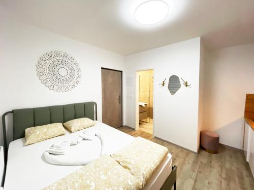 a bedroom with a large white bed and a bathroom at The Maze Apartment in Ljubljana