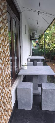 a row of tables and benches on the side of a building at Aurelle Villa in Unawatuna