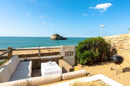- un salon avec un canapé et une vue sur la plage dans l'établissement AROHA Apt with terrasse and sea view in Biarritz, à Biarritz