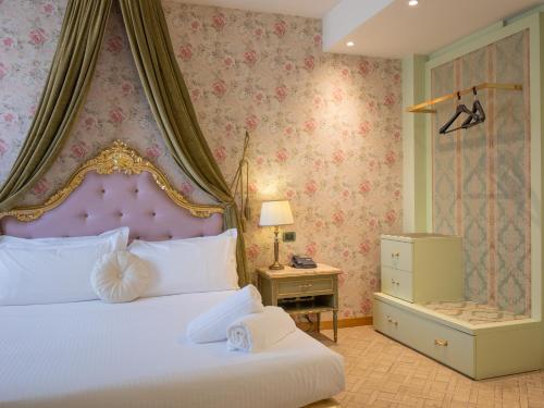 a bedroom with a white bed with a pink headboard at San Valentino Hotel in Villa di Serio