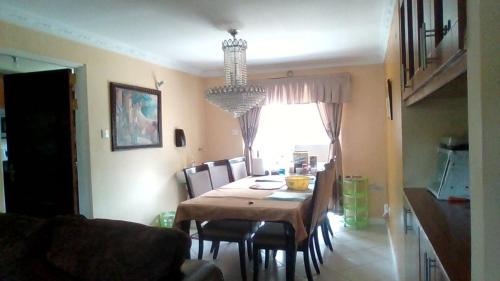 a dining room table with chairs and a chandelier at Jo-Casa in Athi River