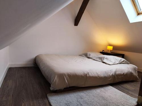 une chambre avec un lit avec une lampe et un tapis dans l'établissement Duplex - Proche Gare & Centre, à Compiègne