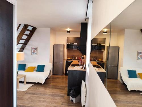 une cuisine et un salon avec deux canapés blancs dans l'établissement Duplex - Proche Gare & Centre, à Compiègne