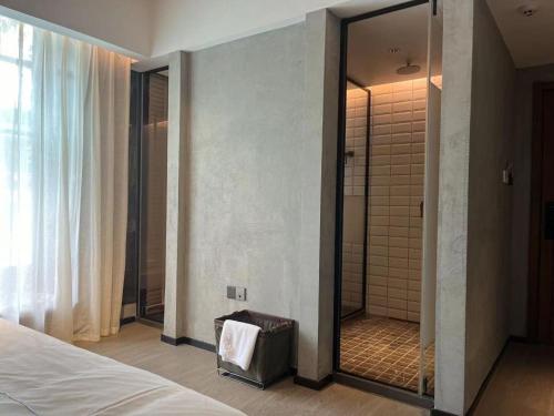 a bedroom with a large mirror and a shower at Wuyuan On The Bound Hotel-婺源水岸边民宿 in Jianlingjue