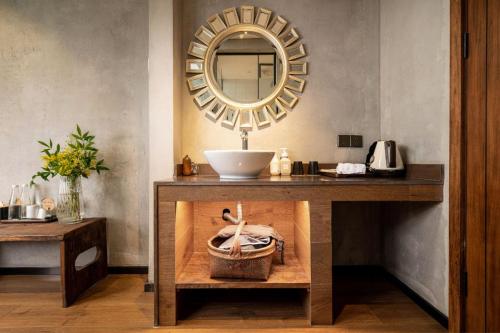 a bathroom with a sink and a mirror on a table at Wuyuan On The Bound Hotel-婺源水岸边民宿 in Jianlingjue
