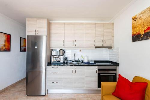 a kitchen with white cabinets and a stainless steel refrigerator at Almodo Suite Patalavaca in Patalavaca