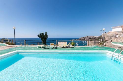 a swimming pool with a view of the ocean at Almodo Suite Patalavaca in Patalavaca