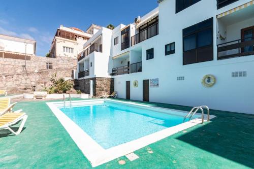 a swimming pool in front of a building at Almodo Suite Patalavaca in Patalavaca