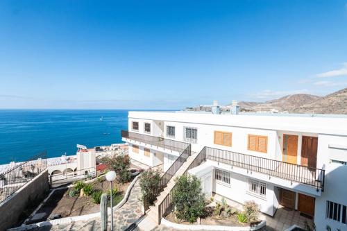 a white building with the ocean in the background at Almodo Suite Patalavaca in Patalavaca