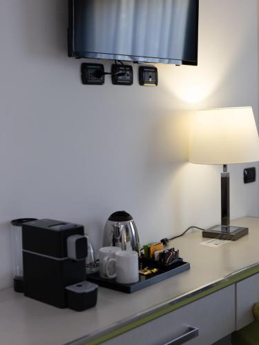 a hotel room counter with a coffee maker and a lamp at San Valentino Hotel in Villa di Serio