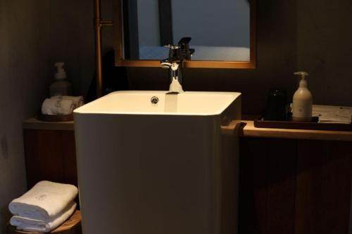 a bathroom with a white sink and a mirror at Wuyuan On The Bound Hotel-婺源水岸边民宿 in Jianlingjue