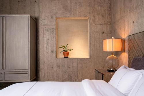 a bedroom with a bed and a potted plant on the wall at Wuyuan On The Bound Hotel-婺源水岸边民宿 in Jianlingjue