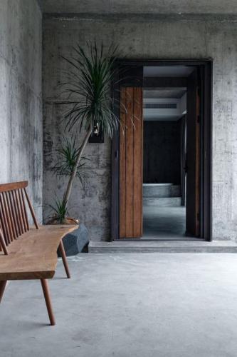 a wooden chair sitting in front of a building at Wuyuan On The Bound Hotel-婺源水岸边民宿 in Jianlingjue