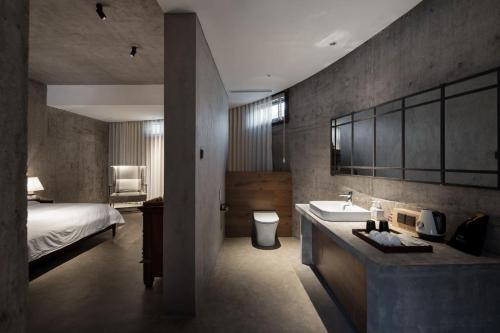 a bathroom with a sink and a bed in a room at Wuyuan On The Bound Hotel-婺源水岸边民宿 in Jianlingjue