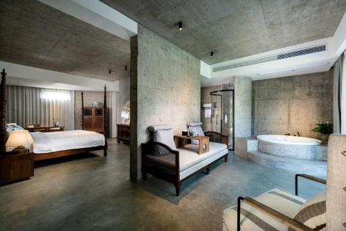 a bedroom with a tub and a bed and a bedroom with a bedzinski at Wuyuan On The Bound Hotel-婺源水岸边民宿 in Jianlingjue