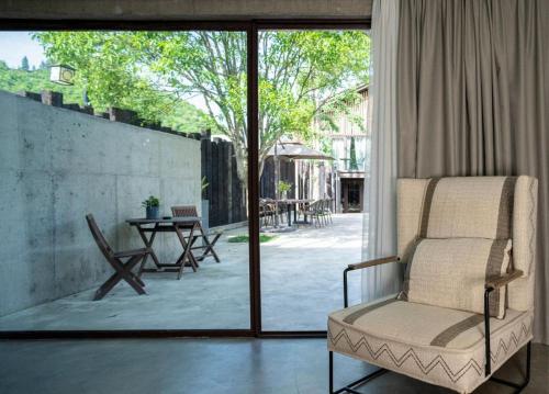 a living room with a chair and a glass door at Wuyuan On The Bound Hotel-婺源水岸边民宿 in Jianlingjue