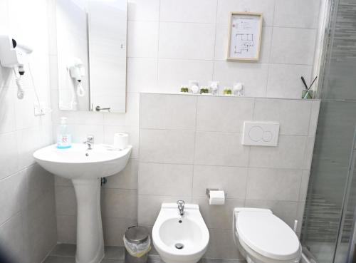 a white bathroom with a sink and a toilet at Appia Antica Guest House in Rome
