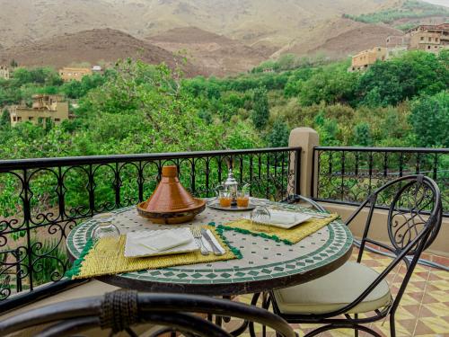 a table with a tea pot on top of a balcony at Tonaroz House in Imlil