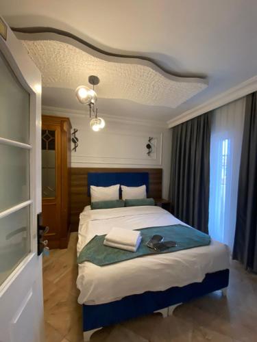 a bedroom with a large bed with a blue headboard at Pembe Köşk Old City Center in Istanbul