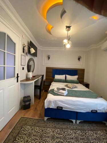 a bedroom with a bed and a desk and a ceiling at Pembe Köşk Old City Center in Istanbul
