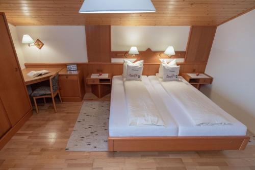 a bedroom with a large bed and a desk at Bio- und Vitalbauernhof Bacherhof in Millstatt