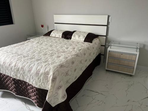 a bedroom with a large bed and two night stands at Residencial ISL - Praia da Pinheira SC in Palhoça