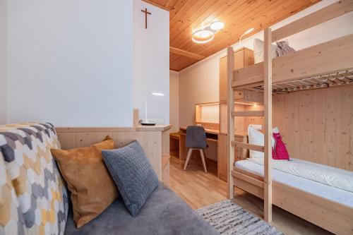 a bedroom with a bunk bed and a desk at Bio- und Vitalbauernhof Bacherhof in Millstatt