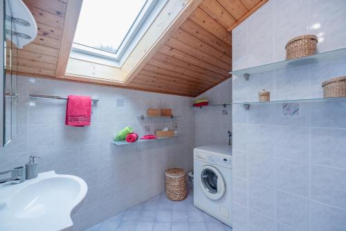 a bathroom with a washing machine and a sink at Bio- und Vitalbauernhof Bacherhof in Millstatt