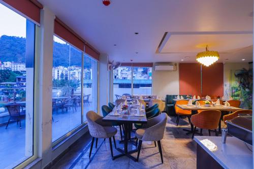 a restaurant with tables and chairs and a large window at Hotel Lords Valley Rishikesh in Rishīkesh