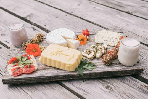 a tray of cheese and meats on a wooden table at Bio- und Vitalbauernhof Bacherhof in Millstatt