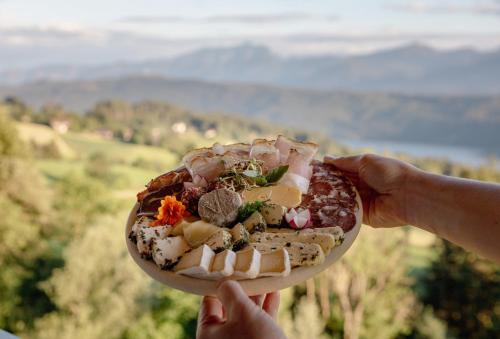 a person holding up a plate of food at Bio- und Vitalbauernhof Bacherhof in Millstatt