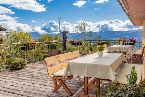 a table and chairs on a deck with a view at Bio- und Vitalbauernhof Bacherhof in Millstatt