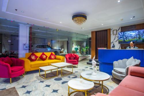 a living room with red and yellow couches and tables at Hotel Lords Valley Rishikesh in Rishīkesh