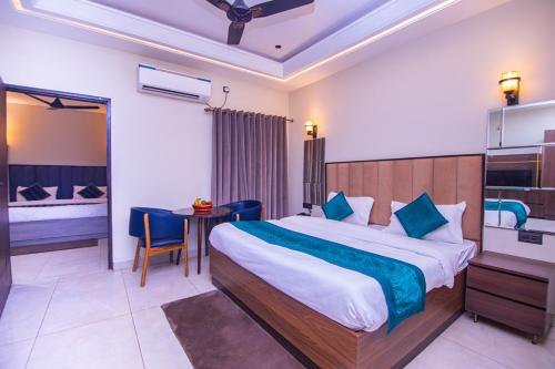a bedroom with a bed and a table in a room at Hotel Lords Valley Rishikesh in Rishīkesh