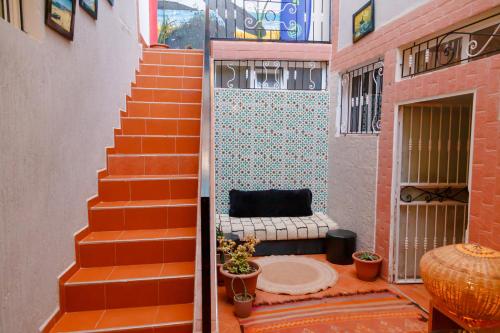 an orange staircase with a bench in a room at Hola Surf Morocco in Agadir