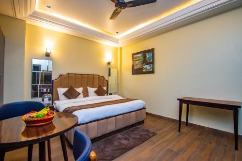 a hotel room with a bed and a table at Hotel Lords Valley Rishikesh in Rishīkesh