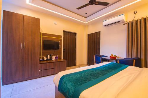 a bedroom with a bed and a flat screen tv at Hotel Lords Valley Rishikesh in Rishīkesh