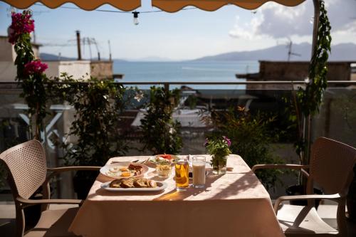 Una mesa con un plato de comida en un balcón. en Jonian Boutique Hotel Sarande, en Sarandë