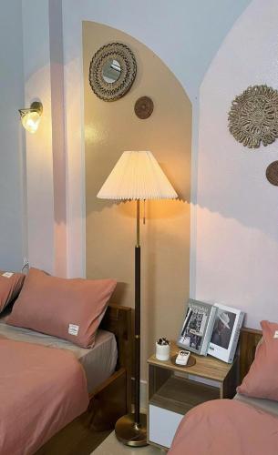 a room with two beds and a table with a lamp at Sen's Homestay - Motorbike Rental - Cao Bang City in Cao Bằng