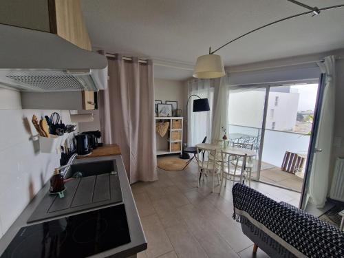 d'une cuisine et d'un salon avec une table et une vue. dans l'établissement Ambre Appart-Wifi-Terrasse-Parking-Terrasse-2 couchages, à La Rochelle